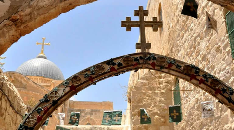 The cross on the ninth station of Via Dolorosa. In the background is the entree to the Coptic Orthodox Patriarchate